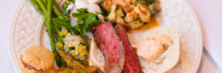 full plate of food with meat, vegetables, pasta and bread