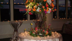 tall flower centerpiece at wedding with sunset backdrop