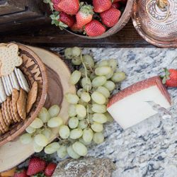cheese, crackers, grapes and strawberries on marble slat