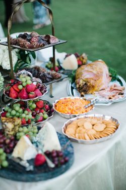 grazing table with crackers, cheese, fruit and meat