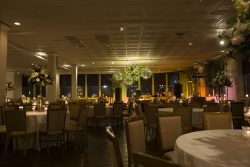 round tables with flower centerpieces in romantically lit wedding receptions space