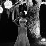 bride in wedding gown standing in front of beautiful oak tree