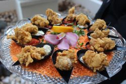 orange lentils underneath fried oysters