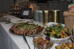 food table at themed wedding featuring lamb chops, olives and roasted potatoes