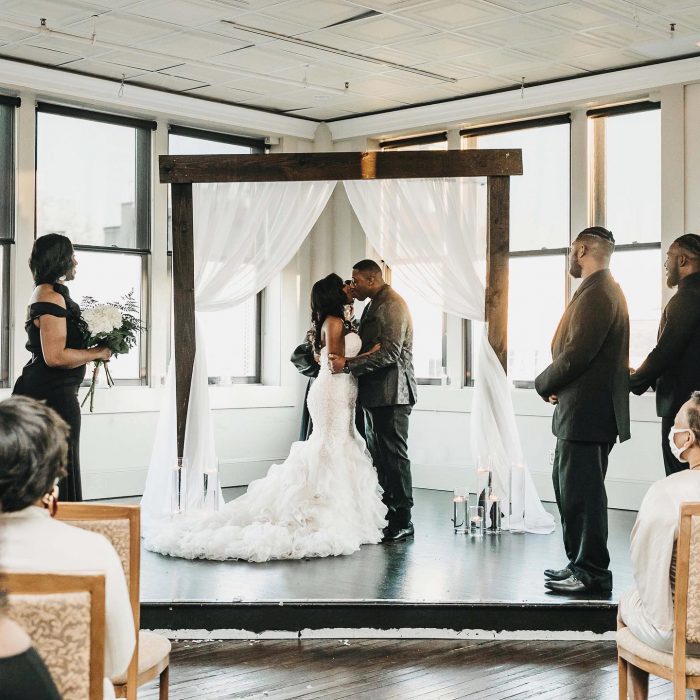 couple kissing in front of large windows at The Martinsborough